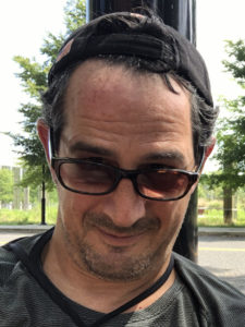 Man with baseball cap, sunglasses, and beard